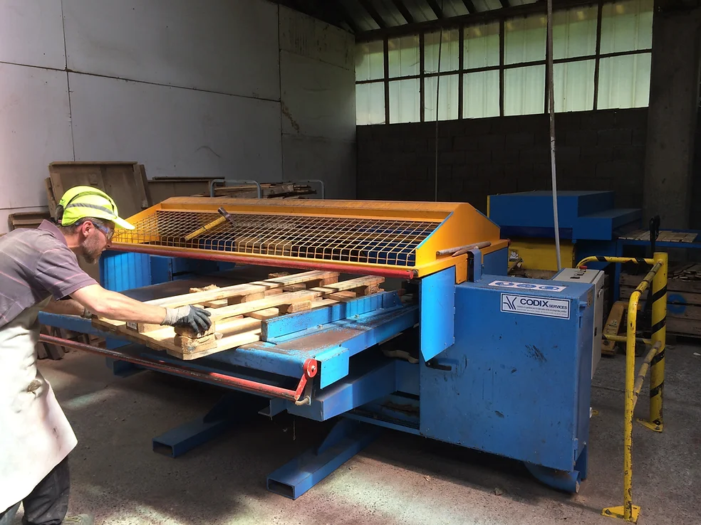 Machine industrielle fabriquant une palette en bois sur-mesure dans l'usine de Bernier Palettes en Savoie.